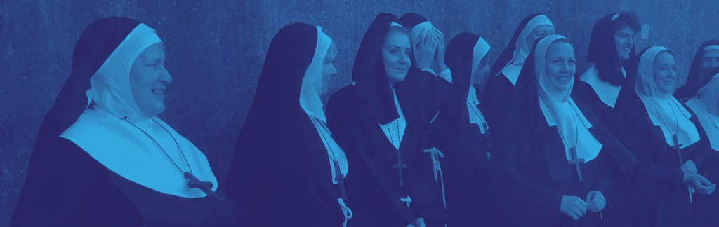 Group of people wearing nun costumes posing for a photograph in a row and smiling.